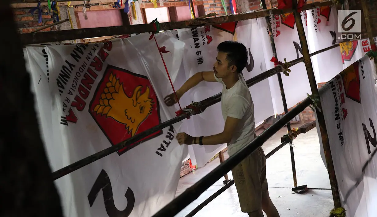 Pekerja menyelesaikan pembuatan atribut partai di Jakarta, Senin (15/10). Dalam sehari, pekerja di pabrik konveksi tersebut bisa memproduksi hingga 2.000 potong atribut partai, mulai dari kaos, bendera, dan topi. (Liputan6.com/Immanuel Antonius)