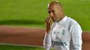 Pelatih Real Madrid, Zinedine Zidane, mengamati anak asuhnya saat latihan di Stadion NY University Abu Dhabi, UAE, Senin (11/12/2017). Los Blancos bersiap jelang semifinal FIFA Club World Cup. (AFP/Giuseppe Cacace)