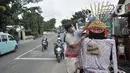 Warga memasangkan masker pada ondel-ondel di depan pintu masuk permukiman RT 12 RW 14, Cipinang Besar Utara, Jakarta, Kamis (16/4/2020). Warga secara swadaya membuat ondel-ondel tersebut sebagai upaya mengajak masyarakat melindungi diri dari penyebaran Covid-19. (merdeka.com/Iqbal S. Nugroho)