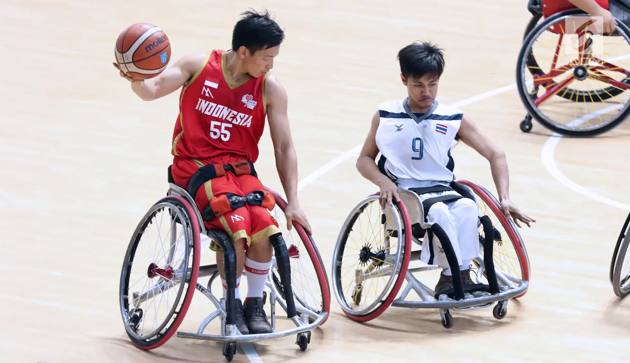 Pebasket difabel Indonesia, Donald P Santoso (kiri) mengecoh kawalan pemain Thailand,Ameen Ha-Rai pada laga Indonesia Para Games Invitational Tournament 2018 di Hall A GBK, Jakarta, Senin (2/7). Indonesia kalah 35-58. (Liputan6.com/Helmi Fithriansyah)