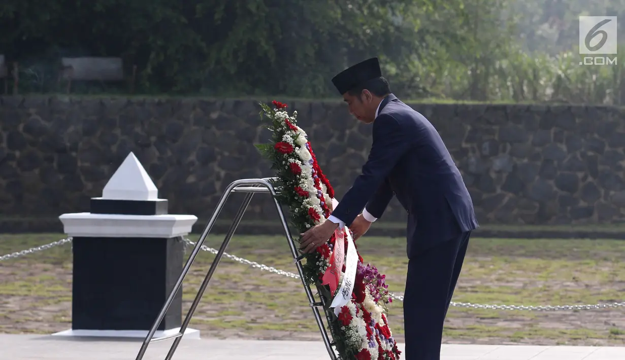 Presiden Joko Widodo memegang rangkaian bunga saat memimpin upacara peringatan Hari Pahlawan Nasional 2018 di TMP Cikutra, Bandung, Sabtu (10/11). Upacara ini untuk mengenang jasa para pahlawan untuk Indonesia.  (Liputan6.com/Angga Yuniar)