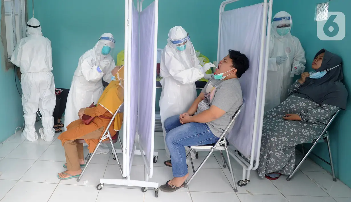Paramedis melakukan swab test PCR kepada warga di Puskesmas Kramat Jati, Jakarta Timur, Rabu (13/1/2020). Setiap harinya, Puskesmas Kramat Jati menyediakan kuota 300 swab test PCR  secara gratis untuk memutus mata rantai penyebaran COVID-19. (merdeka.com/Arie Basuki)