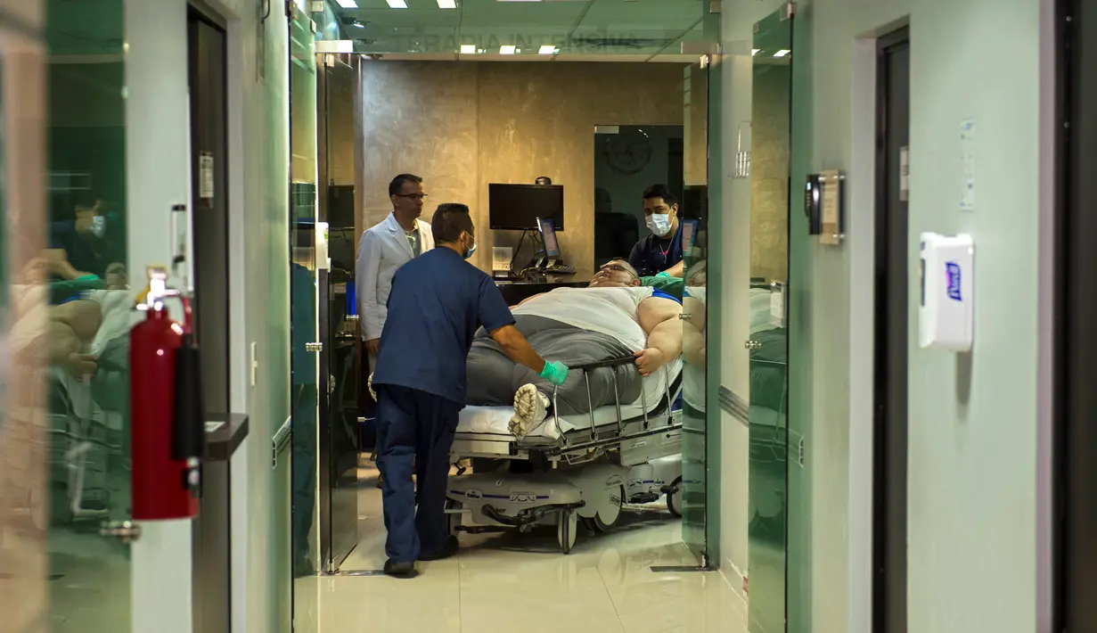 Petugas membawa Juan Pedro Franco yang terbaring di tempat tidur untuk menjalani perawatan di rumah sakit di Guadalajara, Meksiko (5/5). Sebelumnya dia berhasil dioperasi dan mengurangi berat badan hingga 174 kilogram. (AFP Photo/Hector Guerrero)