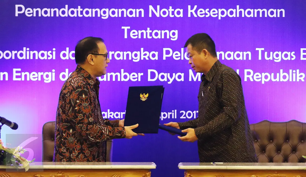 Gubernur Bank Indonesia (BI) Agus Martowardojo (kiri) bersama Menteri ESDM Ignasius Jonan (kanan) bertukar draf perjanjian kerja sama saat penandatanganan di Jakarta, Kamis (13/4). (Liputan6.com/Angga Yuniar)