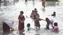 Sejumlah anak-anak bermain di genangan air akibat banjir rob di kawasan pintu masuk Pelabuhan Nizam Zachman, Muara Baru, Jakarta, Jumat (5/6/2020). Banjir rob di Pelabuhan Muara Baru tersebut terjadi akibat cuaca ekstrem serta pasang air laut. (Liputan6.com/Helmi Fithriansyah)