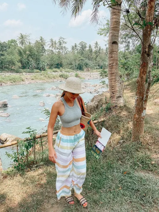 <p>Kali ini, dalam mode liburan, Luna Maya terlihat mengenakan crop to abu-abu, dipadunya dengan celana pantai bermotif garis yang playful, dan topi lebar. Foto: Instagram.</p>