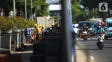 Pekerja menyeselasikan proyek revitalisasi kawasan Kota Tua, Jakarta, Rabu (23/3/2022). Revitalisasi pedestrian ini nantinya akan menjadi plaza pedestrian yang lebar sebagai bentuk penataan kawasan Kota Tua yang rendah emisi dan destinasi pariwisata bersejarah. (merdeka.com/Imam Buhori)