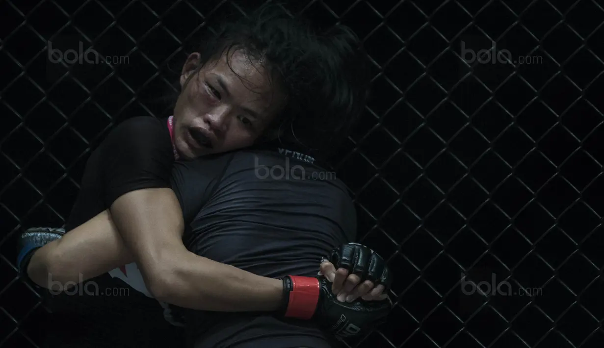 Petarung Singapura, Tiffany Teo, menahan kuncian petarung Cina, Xiong Jing Nan, saat laga One Championship di JCC Senayan, Jakarta, Sabtu (20/1/2018). Jing Nan berhasil merebut juara dunia kelas jerami. (Bola.com/Vitalis Yogi Trisna)