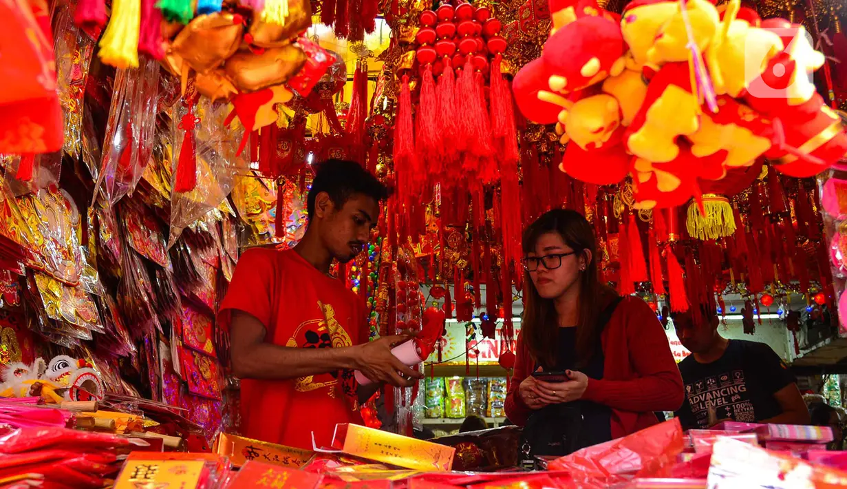 Calon pembeli memilih pernak-pernik Imlek yang dijual di kawasan Glodok, Jakarta, Senin (13/1/2020). Menurut pedagang setempat, menjelang tahun baru Imlek pada 25 Januari mendatang  terjadi peningkatan penjualan pernak-pernik dan hiasan hingga 3 kali lipat. (merdeka.com/Arie Basuki)
