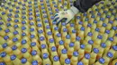 Pekerja memeriksa botol-botol susu kedelai di sebuah pabrik di Nanning, Guangxi, China, Selasa (12/3). Pabrikan asal China menghadapi tekanan penjualan di dalam dan luar negeri. (STR/AFP)
