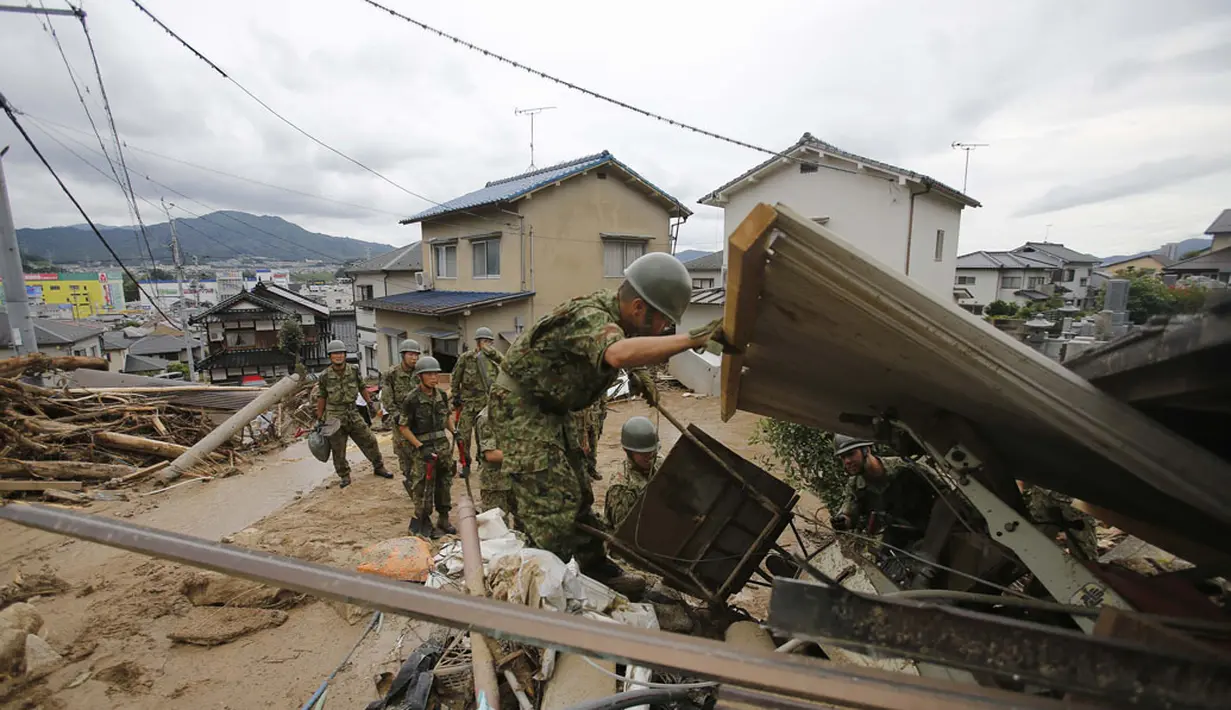 Beberapa Anggota Tentara Bela Diri Jepang terus berupaya melakukan pencarian dan evakuasi korban bencana tanah longsor di wilayah perumahan di Asaminami, Hiroshima, Jepang, (20/8/2014). (REUTERS/Toru Hanai)