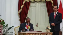 Presiden Guinea, Alpha Conde (kiri) disaksikan Presiden RI Jokowi mengisi buku tamu di Istana Merdeka, Jakarta, Rabu (3/8). Kunjungan tersebut untuk membahas hubungan bilateral kedua negara tersebut. (Liputan6.com/Faizal Fanani)