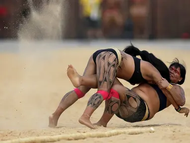 Dua wanita adat sedang bergulat dalam pertandingan yang disebut Huka Huka pada Olimpiade bagi Masyarakat adat, Palmas, Brasil, (30/10/2015). Sekitar 48 etnik yang akan terdiri atas empat ribu atlet ikut dalam Olimpiade ini. (REUTERS/Ueslei Marcelino)