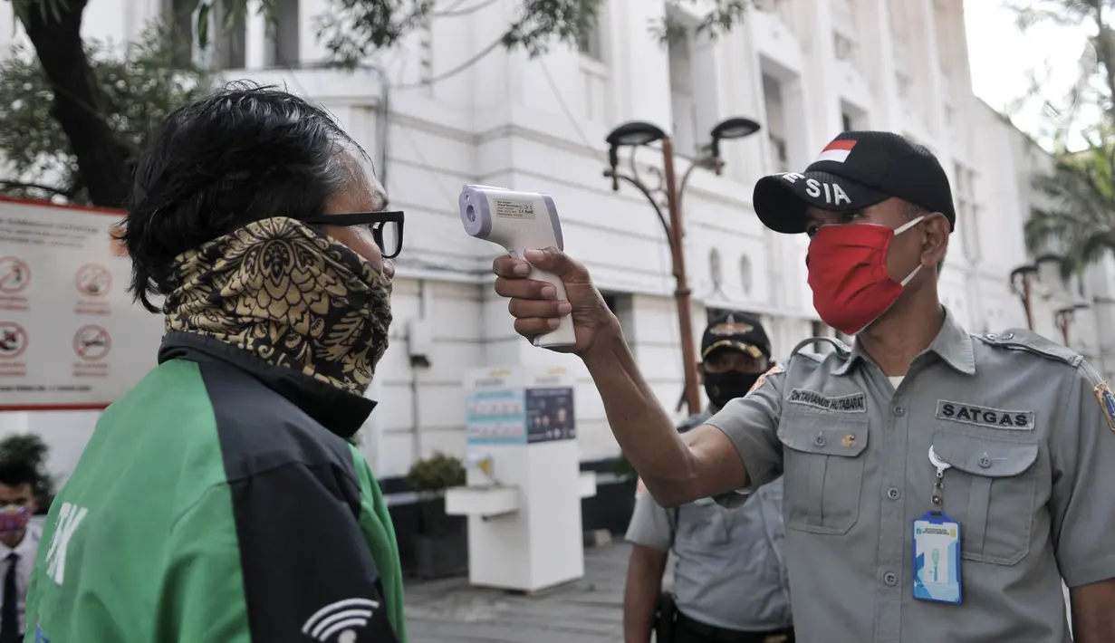 Petugas memeriksa suhu tubuh pengunjung kompleks wisata Kota Tua, Jakarta, Selasa (2/6/2020). Jelang berakhirnya PSBB di Jakarta, pengelola Kota Tua menyiapkan protokol kesehatan new normal bagi pengunjung. (merdeka.com/Iqbal S. Nugroho)