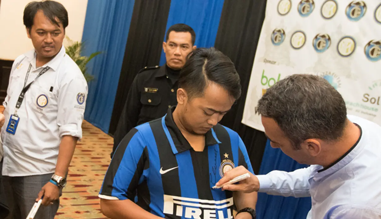 Legenda hidup Inter Milan, Youri Djorkaeff menandatangani jersey milik peserta Gathering Nasional Inter Club Indonesia saat acara Meet and Great Inter Legend di Bali, Jumat (28/8/2015). (Bola.com/Vitalis Yogi Trisna)