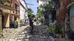 Seorang pria berdiri di samping sebuah rumah yang rusak setelah gempa kuat melanda Vigan, Provinsi Ilocos Sur, Filipina, 27 Juli 2022. Gempa bermagnitudo 7 yang mengguncang Filipina dilaporkan berpusat di daerah pegunungan di Provinsi Abra. (Bureau of Fire Protection via AP)