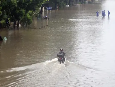 Pengendara memaksa melintasi Jalan Di Panjaitan dekat Halte Transjakarta Cawang Soetoyo, Jakarta, Rabu (1/1/2020). Hujan yang mengguyur Jakarta sejak Selasa sore (31/12/2019) mengakibatkan banjir di sejumlah titik di Jakarta. (Liputan6.com/Helmi Fithriansyah)