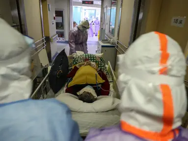 Petugas medis memindahkan seorang pasien yang terinfeksi virus corona COVID-19 di rumah sakit Palang Merah di Wuhan pada 28 Februari 2020. Virus corona baru, Covid-19, telah mewabah hingga ke lebih dari 60 negara dimana dari kasus-kasus infeksi, ada lebih dari 3.000 kematian yang terjadi.  (STR/AFP)