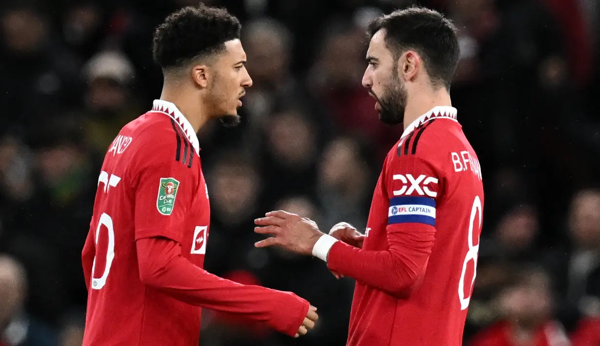 Penyerang Manchester United, Jadon Sancho (kiri) berbicara gelandang Bruno Fernandes saat bertanding melawan Nottingham Forest di leg kedua semifinal Piala Liga Inggris di Old Trafford di Manchester, Inggris, Kamis (2/2/2023). Manchester United menang atas Nottingham Forest dengan skor 2-0. (AFP/Paul Ellis)