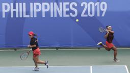 Ganda Indonesia, Priska Nugroho / Rifanty Kahfiani, saat melawan Peangtarin Plipuech / Tamarine Tanasugarn pada SEA Games 2019 di Kompleks Rizal Memorial, Kamis (5/12). Ganda Indonesia kalah 4-6, 7-6 dan 5-10. (Bola.com/M Iqbal Ichsan)