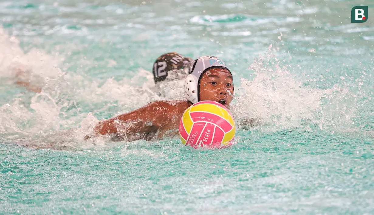 Pemain Pari Sakti (kiri) mencoba mempertahankan bola pada partai final polo air kategori U-14 Indonesia Open Aquatic Championships (IOAC) 2025 di Stadion Akuatik GBK, Jakarta Pusat, pada Kamis (13/11/2025). (Bola.com/Abdul Aziz)