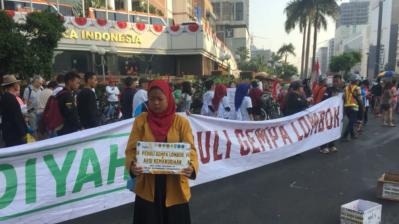Pemuda Muhammadiyah menggalang dana untuk korban gempa Lombok saat car free day (CFD) di kawasan Bundaran Hotel Indonesia (HI), Jakarta. (Liputan6.com/Hanz Jimenez Salim)