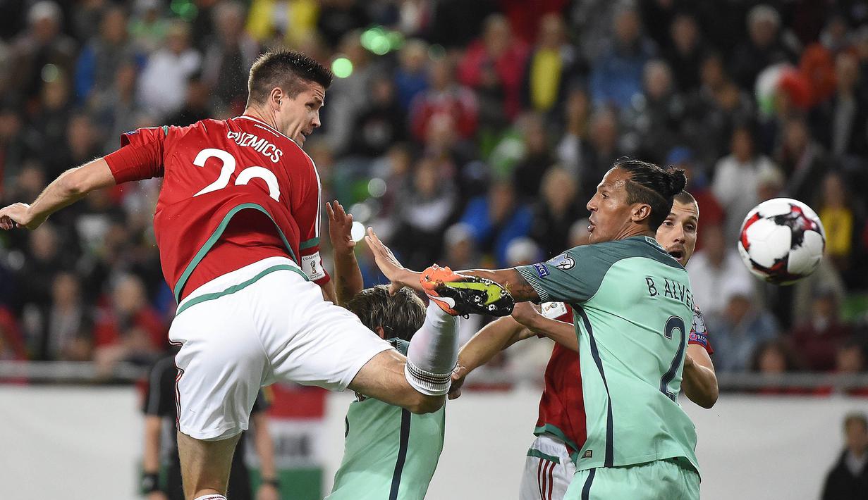 Bek Portugal, Bruno Alves, berusaha menghalau bola sundulan bek Hongaria, Richard Guzmics, pada laga Kualifikasi Piala Dunia 2018 di Stadion Groupama, Minggu (3/9/2017). Portugal menang 1-0 atas Hongaria. (AP/Tamas Kovacs)