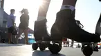 Orang-orang yang mengenakan masker berjalan dekat sepatu roda di Santa Monica, California, Kamis (3/9/2020). Permintaan sepatu roda di Amerika Serikat mengalami peningkatan tajam untuk mencari aktivitas di luar ruangan di tengah pembatasan sosial akibat corona Covid-19. (Mario Tama/Getty Images/AFP)