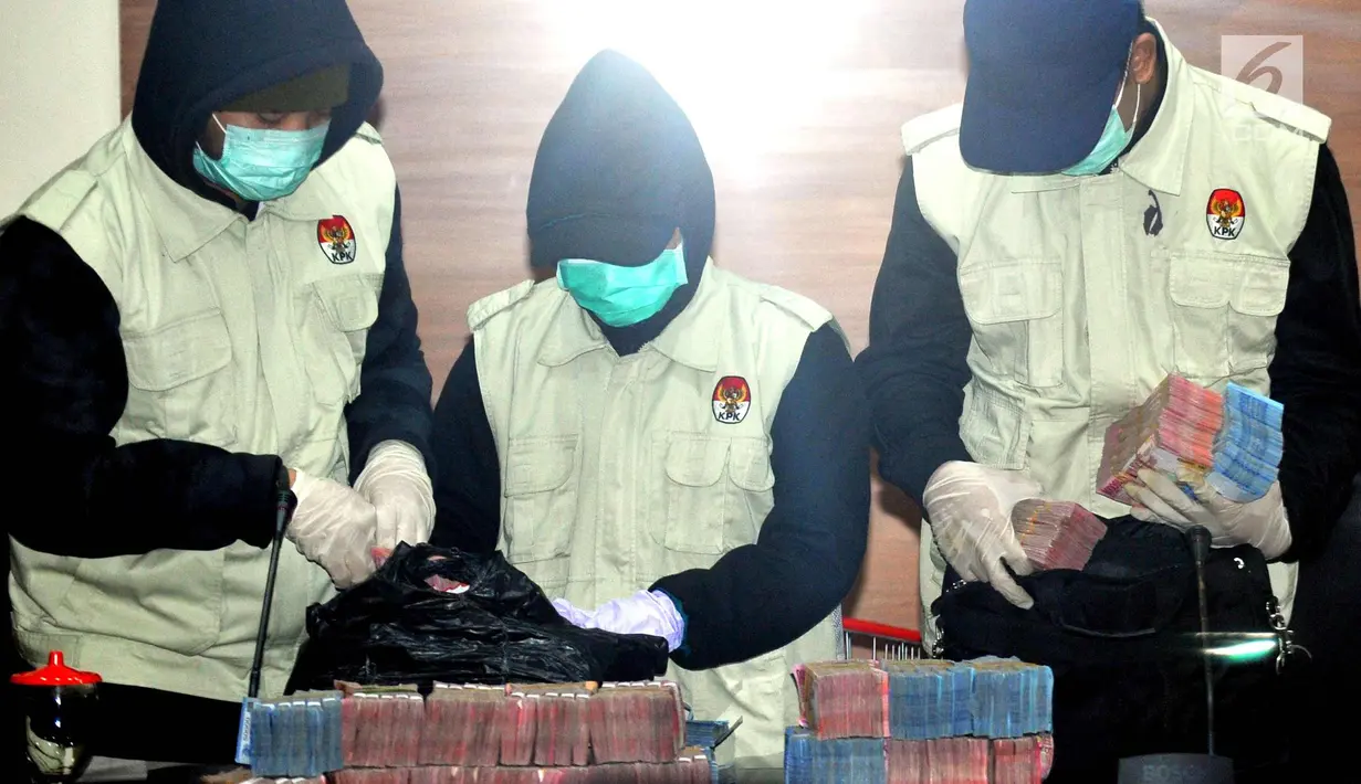 Petugas menunjukkan barang bukti uang hasil OTT sebanyak Rp 1,15 Miliar di gedung KPK, Jakarta, Sabtu (23/9). Walikota Cilegon, TB Iman Aryadi datang menyerahkan diri ke KPK pada Jumat (22/9), malam. (Liputan6.com/Helmi Afandi)