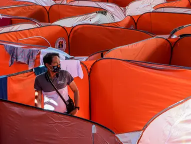 Seorang pria terlihat di sebuah tenda Modular bagi kaum tunawisma guna menghentikan penyebaran COVID-19 di sebuah lapangan basket beratap di Manila, 23 Maret 2020. Jumlah kasus infeksi virus corona meningkat menjadi 501, menurut Otoritas kesehatan Filipina, pada Selasa (24/3). (Xinhua/Rouelle Umali)