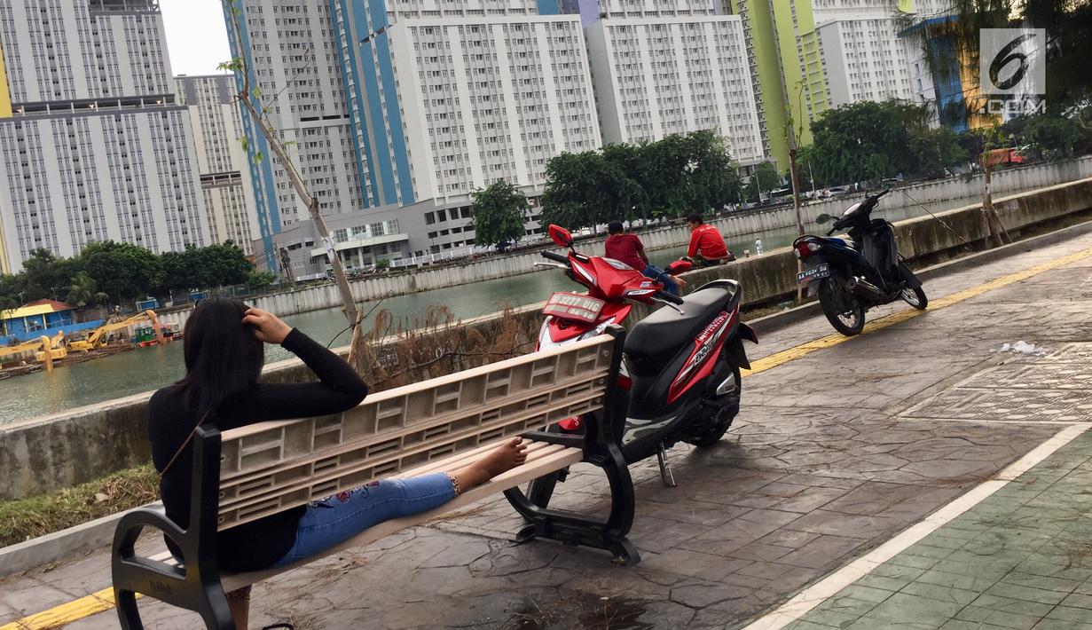 Warga memarkirkan kendaraannya di trotoar saat bersantai di Danau Sunter, Jakarta, Jumat (19/1). Meskipun telah dibenahi, masih banyak warga yang memarkirkan sepeda motornya di trotoar tersebut. (Liputan6.com/Immanuel Antonius)