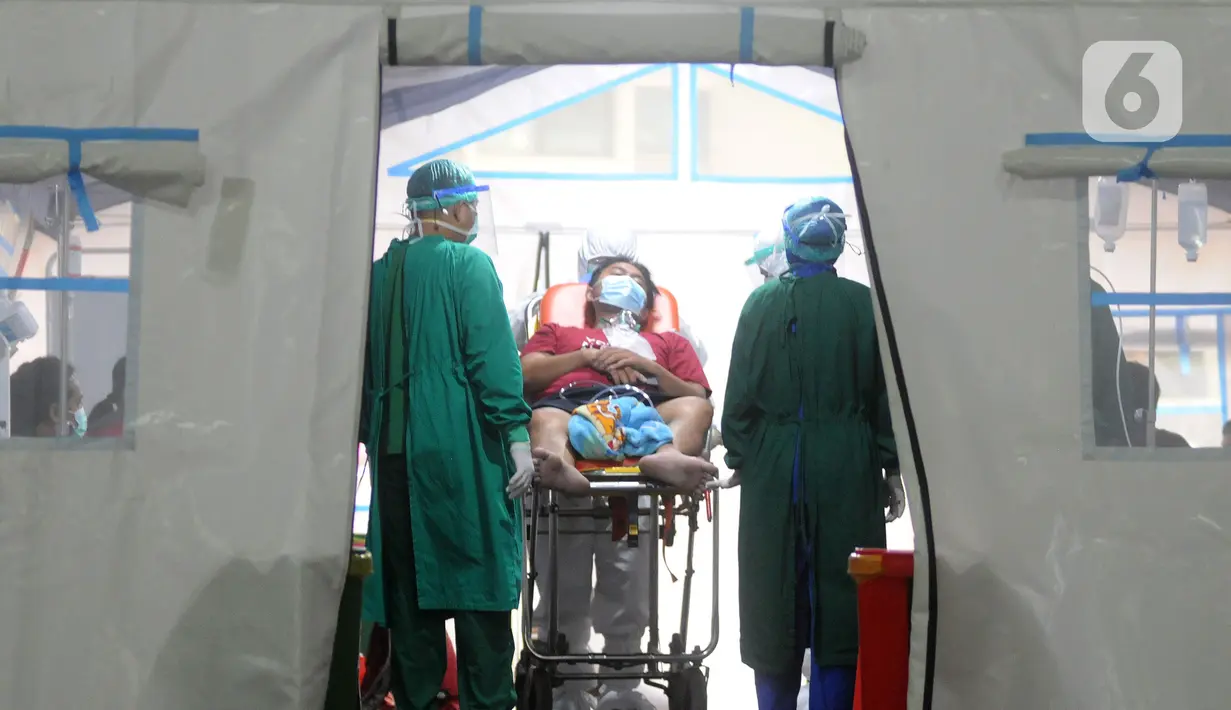 Petugas medis merawat pasien di dalam tenda darurat di depan UGD RSUD Cengkareng, Jakarta Barat, Kamis (24/6/2021). Lonjakan kasus virus corona mengakibatkan ruang IGD penuh, pihak rumah sakit lantas mendirikan tenda darurat untuk merawat pasien covid-19. (merdeka.com/Arie Basuki)