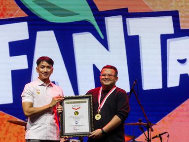 Senior Manager Museum Rekor Indonesia (MURI), Triyono (kiri) menyerahkan piagam ke Frontline Brand Manager The Coca-Cola Company Muhammad Maulana Soesetyo saat acara KapanLagi Pensi Bareng Fanta 2025 di Gelanggang Olahraga (GOR) atau Gelanggang Mahasiswa Soemantri Brodjonegoro, Jakarta, Sabtu (28/6/2025). (Liputan6.com/Herman Zakharia)