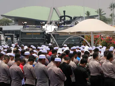 Polisi dan massa aksi 299 melakuan salat Jumat di depan Gedung MPR/DPR, Jakarta, Jumat (29/9). Aksi  tersebut menolak Peraturan Pemerintah Pengganti Undang-Undang Nomor 2 Tahun 2017 tentang Perppu Ormas. (Liputan6.com/Johan Tallo)