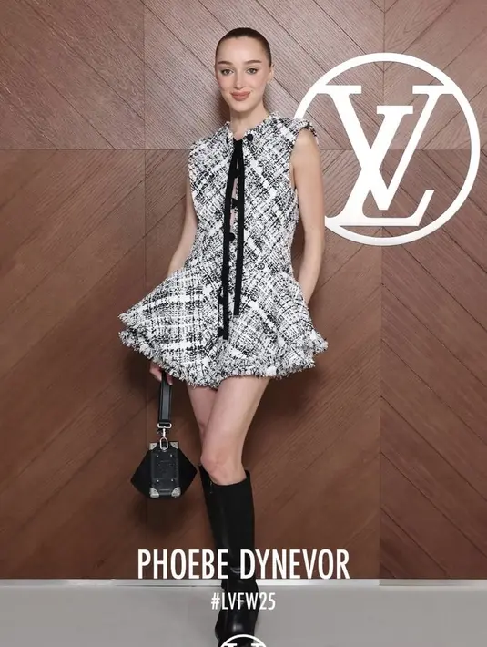 Phoebe Dynevor mengenakan mini dress warna hitam putih dengan aksen pita panjang warna hitam senada dengan warna mini bag dan knee boots leather nya.  [dok. Louis Vuitton]