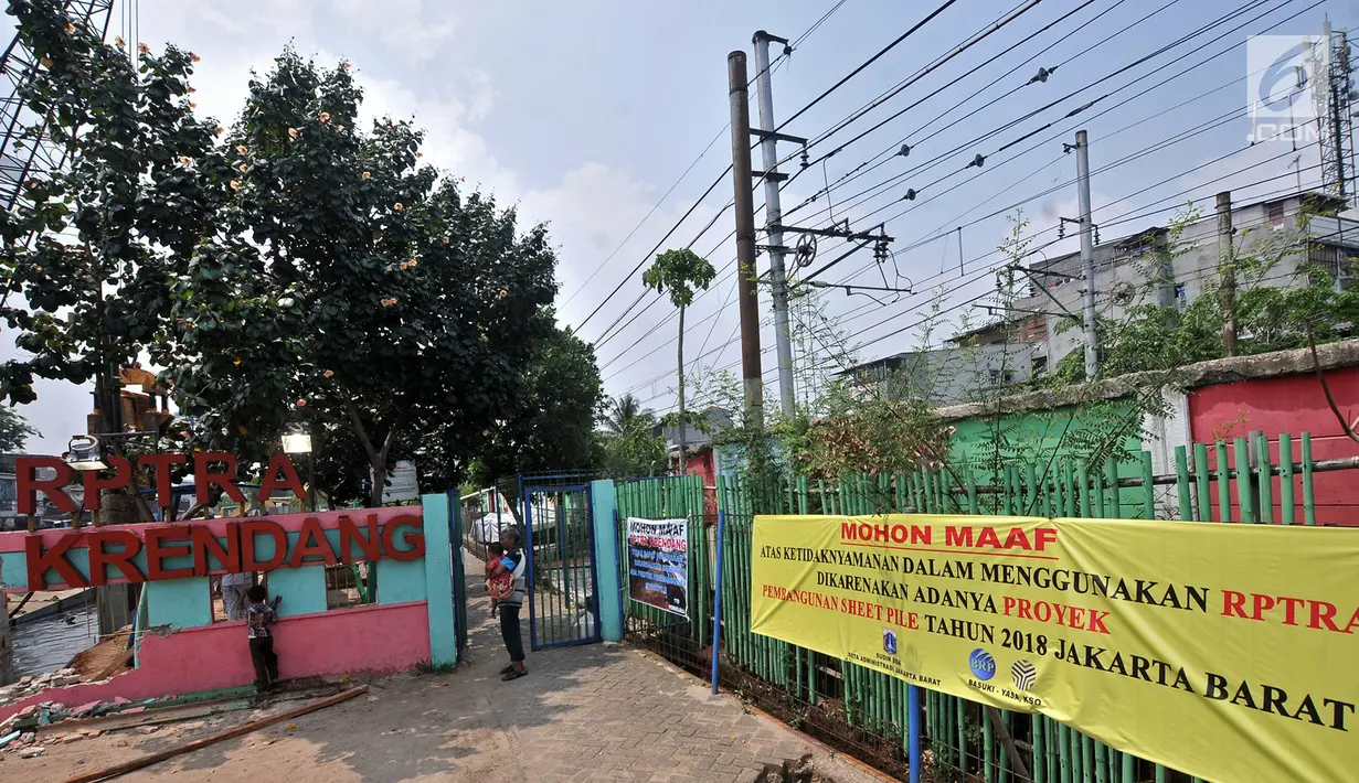 Warga melihat pengerjaan dinding turap di depan RPTRA Krendang yang ditutup sementara, Jakarta, Kamis (25/10). RPTRA Krendang akan dibuka kembali pada Desember mendatang atau hingga pemasangan turap selesai. (Merdeka.com/Iqbal Nugroho)