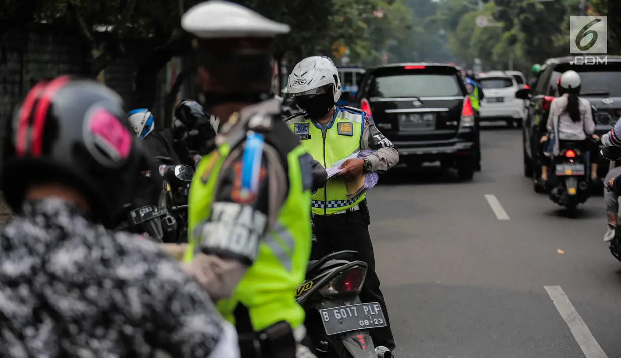 Polisi lalu lintas memeriksa kelengkapan surat pengendara saat razia Operasi Patuh Jaya 2019 di kawasan Kemanggisan, Jakarta, Kamis (29/8/2019). Operasi ini diharapkan dapat meningkatkan kepatuhan dan ketertiban dalam berlalu lintas serta mengurangi angka kecelakaan. (Liputan6.com/Faizal Fanani)