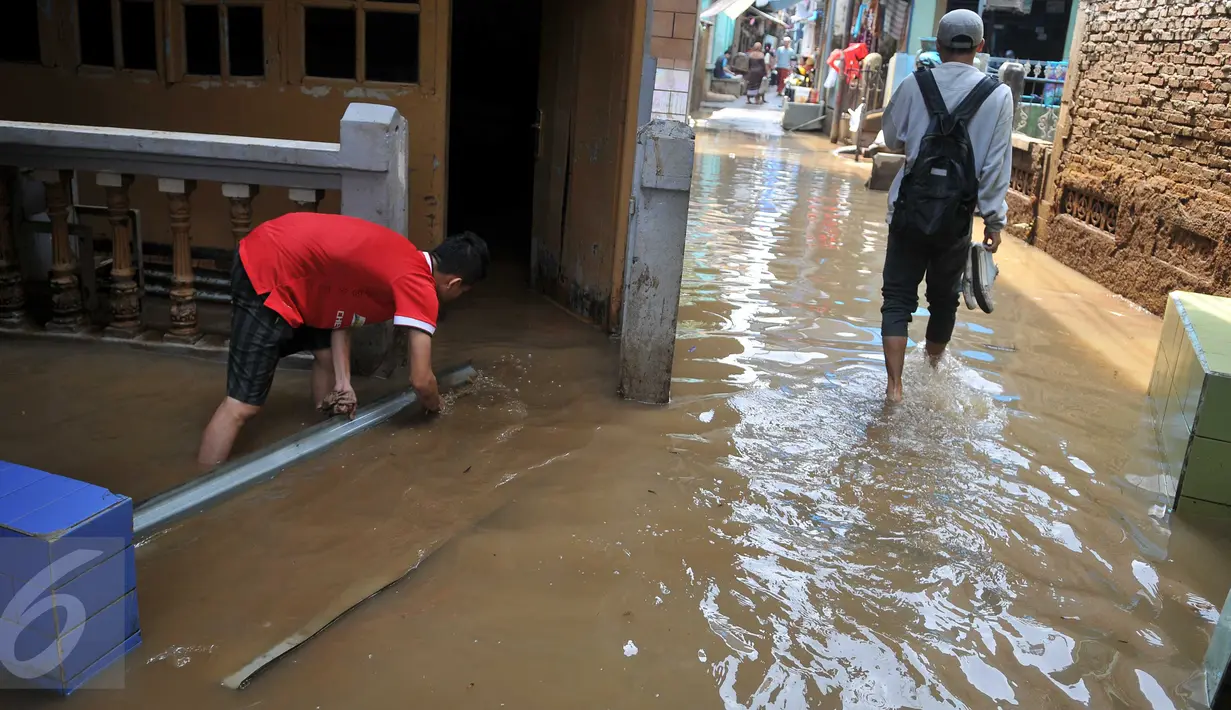 Warga mulai beraktivitas menyusul surutnya air yang sempat merendam pemukiman mereka di kawasan Kampung Pulo, Jakarta, Selasa, (17/11). (Liputan6.com/Gempur M Surya)