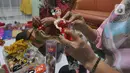 Ibu rumah tangga menyelesaikan pembuatan boneka adat Indonesia di Ammie Dolls di Komplek Pondok Tirta, Depok, Kamis (13/08/2020). Pada masa pandemi ini produksi dan penjualan anjlok hingga 95 persen menyebabkan perajin beralih ke bidang lain untuk mencukupi kebutuhan hidup. (merdeka.com/Arie Basuki)