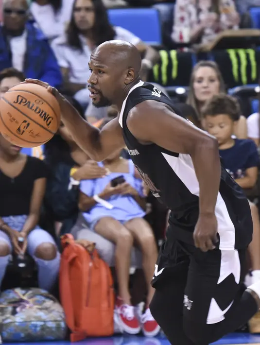 Petinju asal AS, Floyd Mayweather mendribble bola saat bertanding pada acara Monster Energy Outbreak Presents $50K Charity Challenge Celebrity Basketball Game di UCLA's Pauley Pavilion di Westwood, California (17/7). (AFP Photo/Vivien Killilea)