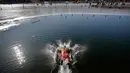 Seorang pria menyelam ke air setengah beku di Danau Shichahai di Beijing, China (24/1). Menurut beberapa penduduk setempat, berenang di air dingin baik untuk kesehatan. (AP Photo / Andy Wong)