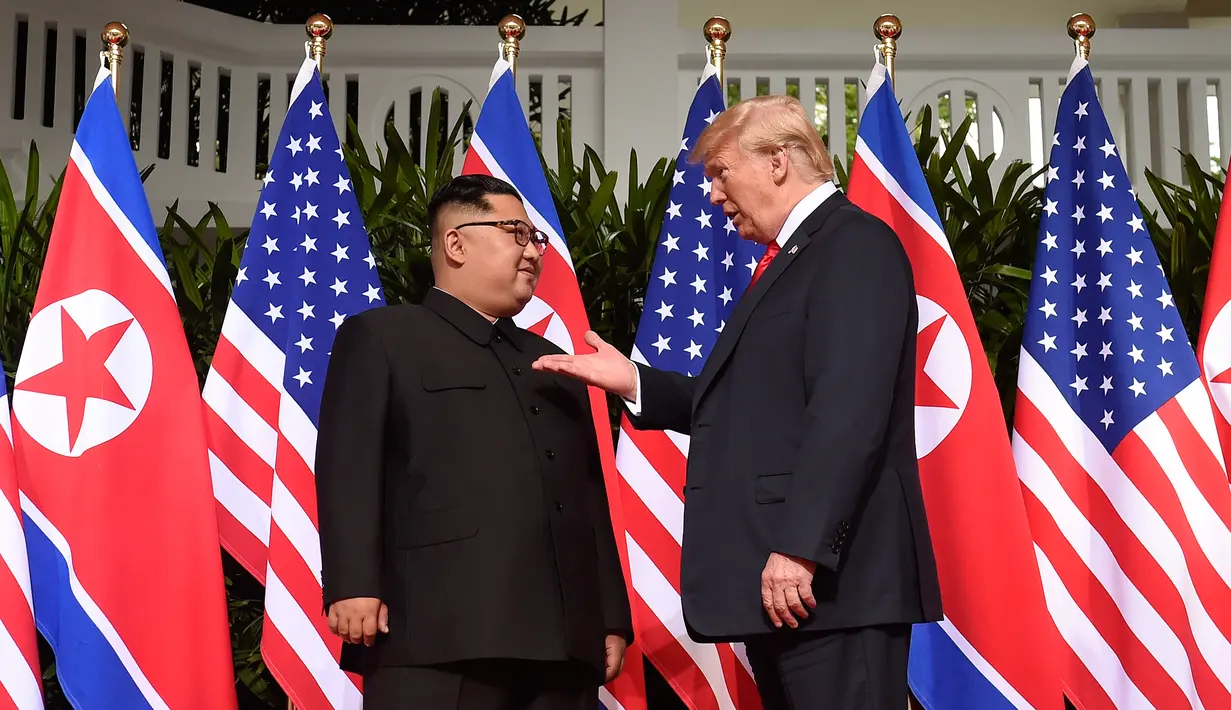 Presiden AS, Donald Trump bertemu dengan Pemimpin Korea Utara, Kim Jong-un di resor Capella, Pulau Sentosa, Singapura, Selasa (12/6). Pertemuan ini merupakan yang pertama kalinya bagi pemimpin AS dan Korut untuk bertatap muka. (SAUL LOEB/AFP)