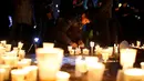 Seorang pria menyalakan lilin saat unjuk rasa menuntut penggulingan Presiden Park Geun-hye pada malam pergantian tahun di Seoul, Korsel, Sabtu (31/12). Sedangkan Korut mengawali Tahun Baru dengan pertunjukan kembang api di Pyongyang. (REUTERS/Kim Hong-Ji)