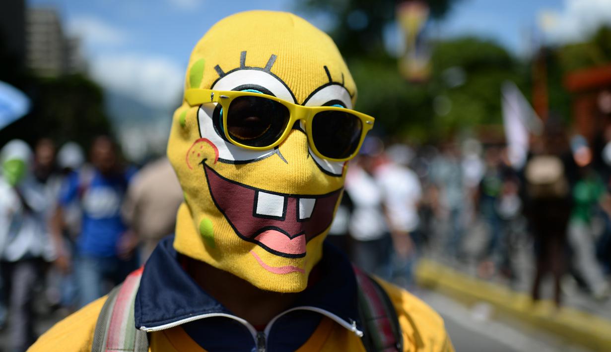Seorang demonstran menggunakan penutup wajah berkarakter SpongeBob saat unjuk rasa menuntut Presiden Venezuela, Nicolas Maduro mundur di Caracas, Venezuela, (6/7). (AP Photo / Federico Parra)
