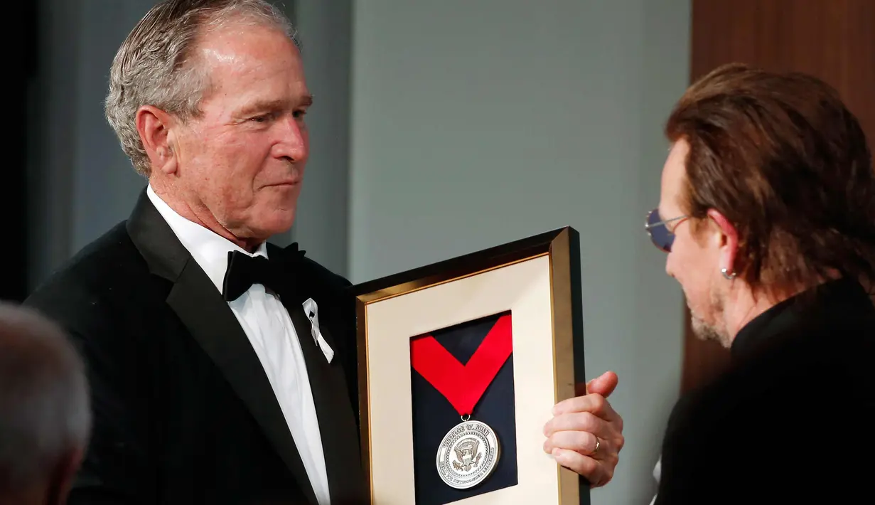 Presiden AS ke-43 George W. Bush (kiri) memberikan medali Distinguished Leadership kepada vokalis U2 Bono selama gala untuk Forum Kepemimpinan di Institut George W. Bush di Dallas, AS (19/4). (AP Photo/Brandon Wade)