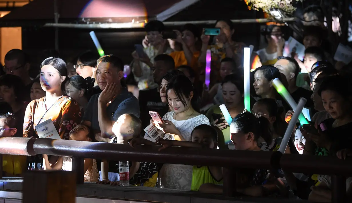 Sejumlah orang menonton pertunjukan di kota kuno Tangqi, Distrik Yuhang, Hangzhou, Provinsi Zhejiang, China, 14 Agustus 2020. Beragam acara digelar setiap Selasa hingga Sabtu malam guna menambah pilihan kegiatan warga di waktu senggang dan mendongkrak perekonomian lokal. (Xinhua/Xu Yu)