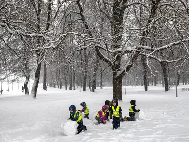 Anak-anak bermain salju setelah hujan salju lebat di Vilnius, Lituania, Jumat, 9 Desember 2022. Salju terus turun di seluruh negeri, dengan suhu hanya 0 derajat Celcius (32,0 derajat Fahrenheit). (AP Photo/Mindaugas Kulbis)