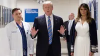 Presiden AS Donald Trump (tengah) didampingi istrinya Melania Trump (kanan) dan dokter Igor Nichiporenko (kiri) saat mengunjungi rumah sakit Broward Health North Pompano Beach, Florida (16/2). (AFP Photo/Jim Watson)