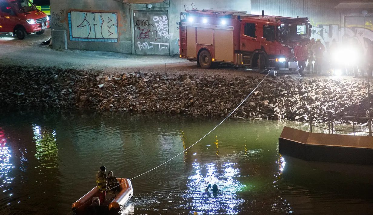 Regu penyelamat mencari korban kecelakaan mobil di kanal di bawah jembatan jalan raya E4 di Sodertalje, Swedia, Sabtu (13/2). Empat anggota band Viola Beach dari Inggris dan manajernya tewas dalam kecelakaan tersebut. (JOHAN NILSSON/TT NEWS AGENCY/AFP)