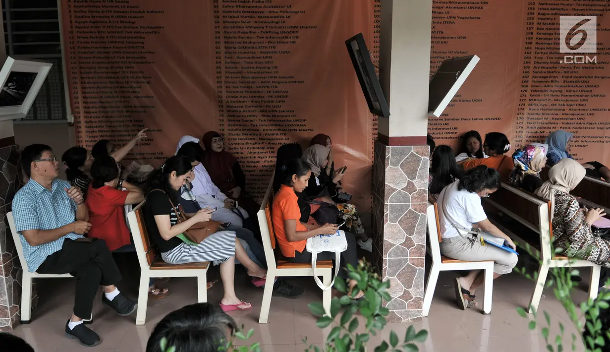 Orangtua murid menunggu antrean pengambilan nomor token PPDB DKI Jalur Zonasi di SMA Negeri 21, Jakarta, Senin (24/6/2019). Pada hari pertama, lebih dari 750 calon peserta didik baru telah mendaftar di SMA Negeri 21. (merdeka.com/Iqbal Nugroho)